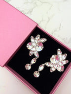 Pair of statement crystal dangle ballroom dance earrings in a pink box on a marble surface